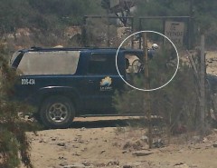 Suburban con puerta abierta y motor en marcha. Sujeto al volante y motopatrullero llegando.